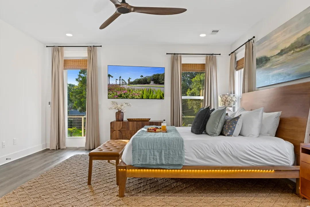 Primary bedroom with a king bed, natural linens, and a leafy view