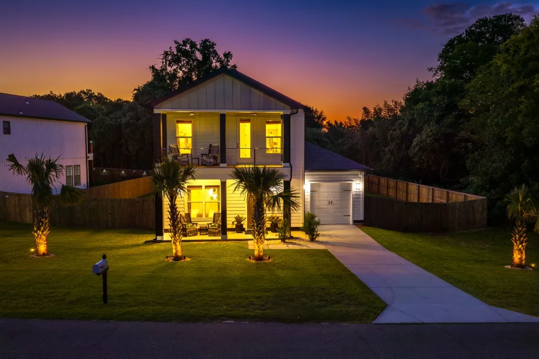 A sunlit North Charleston home framed by palms and a covered porch